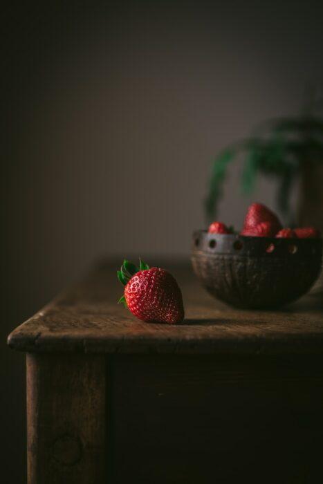 red strawberries on brown wooden table